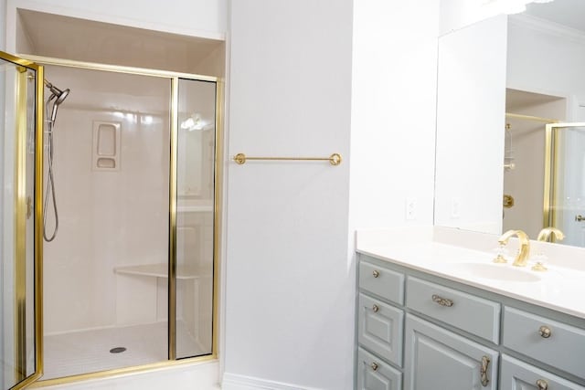 full bath featuring vanity, ornamental molding, and a shower stall