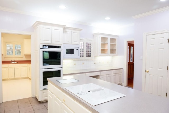 kitchen with white appliances, crown molding, decorative backsplash, and light countertops