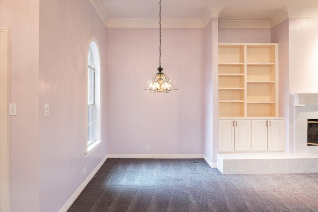 interior space featuring baseboards, ornamental molding, a tiled fireplace, and dark colored carpet