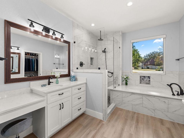 103 Waters Edge, Horseshoe Bay, TX 78657 - full bathroom featuring a bath, vanity, tiled shower, wood finished floors, and recessed lighting