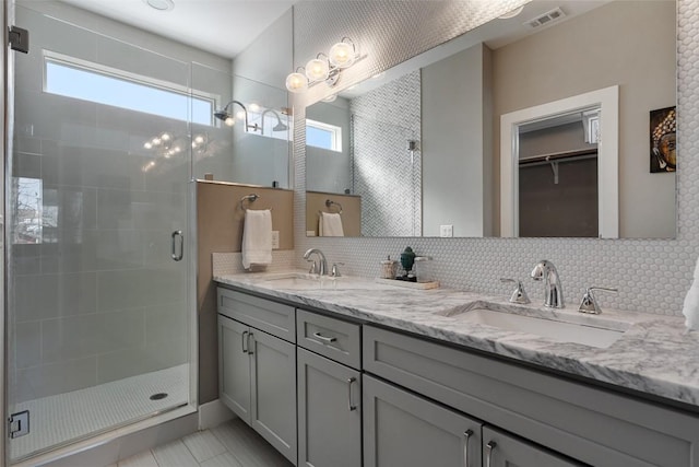 2514 E 4th St Unit A, Austin, TX 78702 - bathroom featuring a shower stall, double vanity, backsplash, a walk in closet, and tile patterned flooring