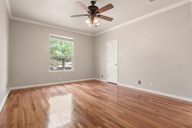 empty room with crown molding, ceiling fan, wood finished floors, and baseboards