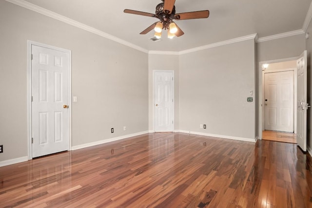 spare room with baseboards, wood finished floors, ceiling fan, and crown molding