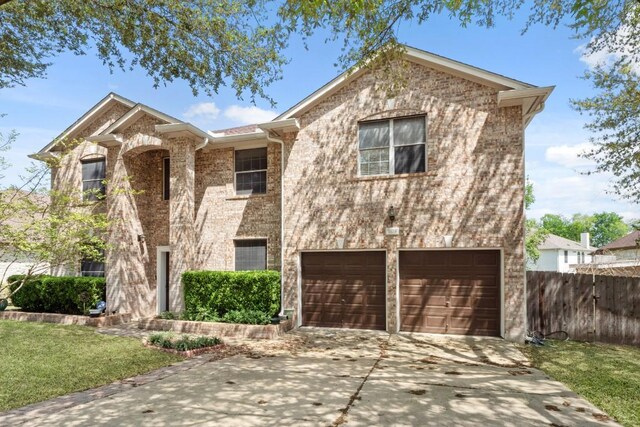 view of front of property with brick siding, fence, a garage, driveway, and a front yard