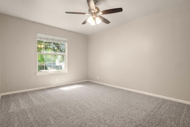 carpeted empty room featuring baseboards and a ceiling fan