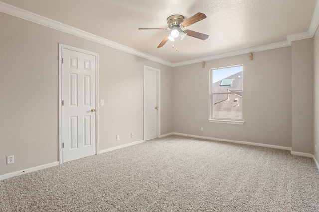 carpeted empty room with ornamental molding, ceiling fan, and baseboards