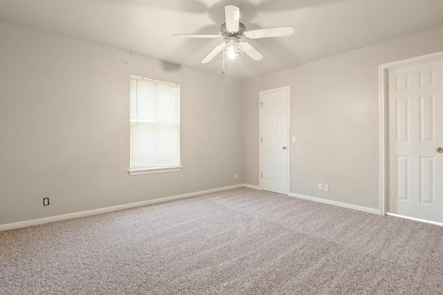 empty room featuring a ceiling fan, carpet, and baseboards