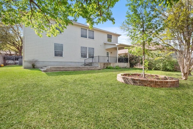 rear view of property with fence and a yard