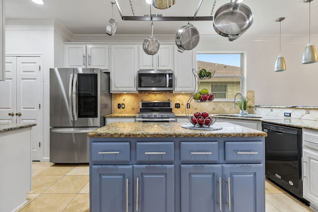 1103 Vanderbilt Cir, Pflugerville, TX 78660 - kitchen featuring appliances with stainless steel finishes, blue cabinetry, light tile patterned floors, white cabinets, and ornamental molding
