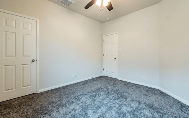 empty room featuring a ceiling fan, baseboards, dark colored carpet, and visible vents