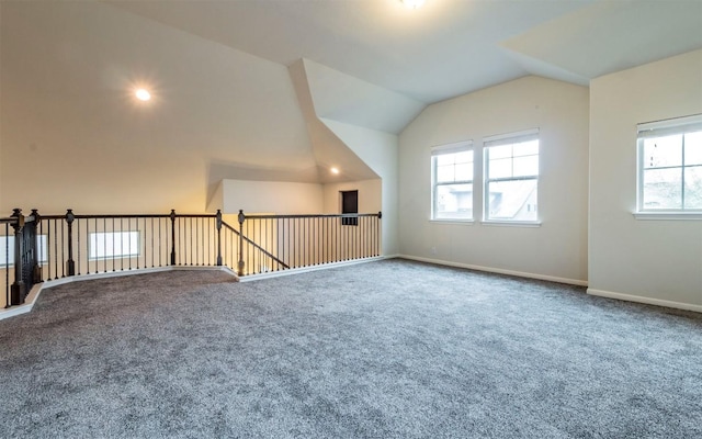 additional living space featuring carpet, lofted ceiling, and baseboards