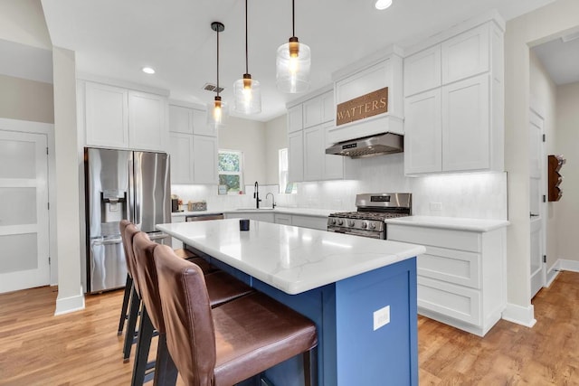 414 Wesley Ridge Dr, Spicewood, TX 78669 - kitchen with stainless steel appliances, a kitchen island, recessed lighting, tasteful backsplash, and a breakfast bar
