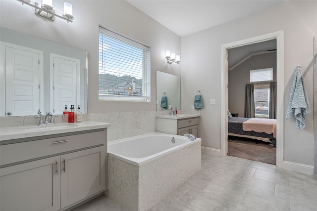 308 Highland Village Cv, Austin, TX 78738 - ensuite bathroom featuring two vanities, a bath, baseboards, and tile patterned flooring