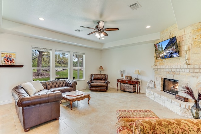 334 Sapling Dr, Driftwood, TX 78619 - living room featuring a raised ceiling, a ceiling fan, a fireplace, recessed lighting, and light tile patterned flooring
