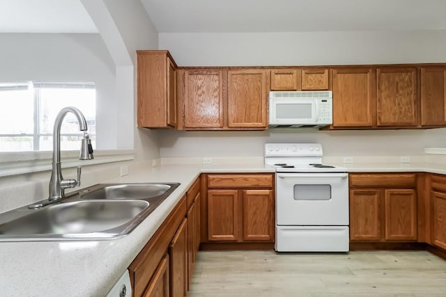 11817 Bastrop St, Manor, TX 78653 - kitchen featuring white appliances, brown cabinets, light wood-type flooring, and light countertops