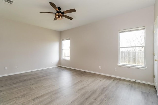 unfurnished room with light wood finished floors, baseboards, visible vents, and ceiling fan