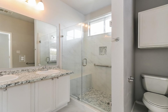 bathroom with a shower stall, visible vents, toilet, and a sink