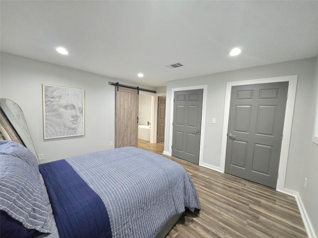 507 W 1st St, Flatonia, TX 78941 - bedroom featuring a barn door, wood finished floors, and recessed lighting