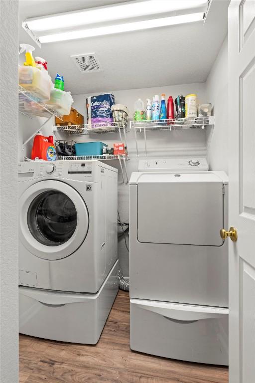 2319 Rock Ledge Dr, Georgetown, TX 78626 - washroom with washing machine and clothes dryer and wood finished floors