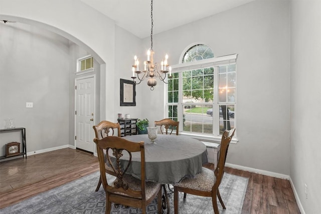 2319 Rock Ledge Dr, Georgetown, TX 78626 - dining area with arched walkways, a chandelier, wood finished floors, and a towering ceiling
