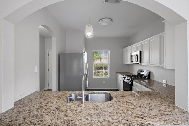 720 Northcreek Blvd, Leander, TX 78641 - kitchen with appliances with stainless steel finishes, light stone counters, white cabinetry, and decorative light fixtures