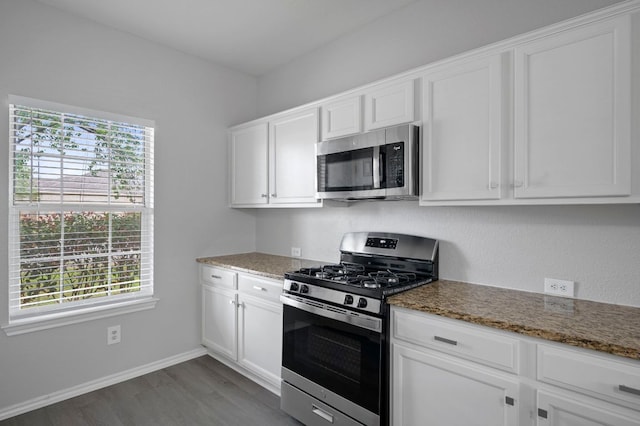 720 Northcreek Blvd, Leander, TX 78641 - kitchen featuring appliances with stainless steel finishes, dark wood-type flooring, stone counters, and white cabinets