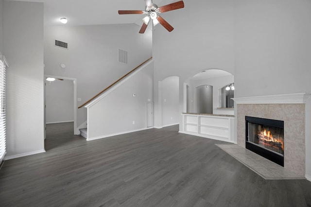 720 Northcreek Blvd, Leander, TX 78641 - unfurnished living room with high vaulted ceiling, a ceiling fan, stairway, dark wood finished floors, and arched walkways
