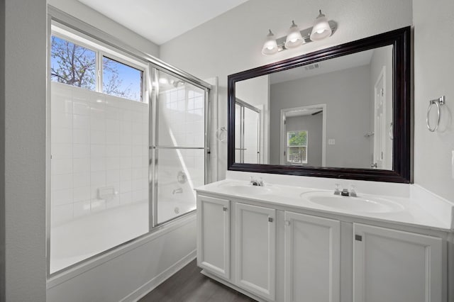 720 Northcreek Blvd, Leander, TX 78641 - full bath with double vanity, enclosed tub / shower combo, and wood finished floors