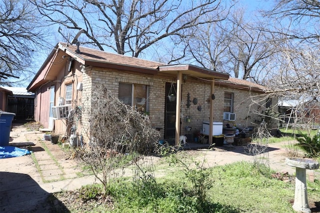 110 Hergotz Ln, Austin, TX 78742 - back of property with brick siding, cooling unit, and roof with shingles