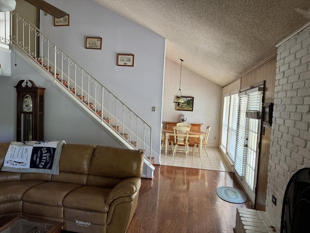 11202 Balcones Woods Cv, Austin, TX 78759 - living area featuring vaulted ceiling, a textured ceiling, wood finished floors, and stairway