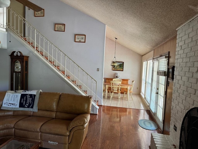 11202 Balcones Woods Cv, Austin, TX 78759 - living room with vaulted ceiling, a textured ceiling, stairs, and wood finished floors