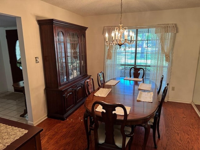 11202 Balcones Woods Cv, Austin, TX 78759 - dining area with a chandelier, a textured ceiling, and dark wood-style flooring