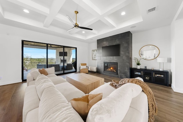 living room featuring ceiling fan, visible vents, wood finished floors, and coffered ceiling