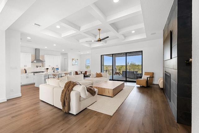 living room with dark wood-style flooring, ceiling fan, beam ceiling, recessed lighting, and coffered ceiling
