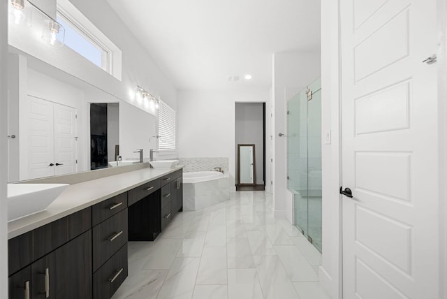 full bathroom with vanity, a stall shower, a garden tub, and marble finish floor