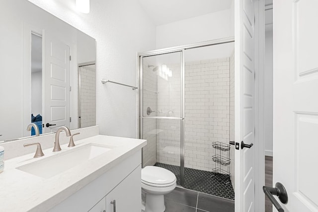 full bathroom with vanity, tile patterned floors, toilet, and a shower stall