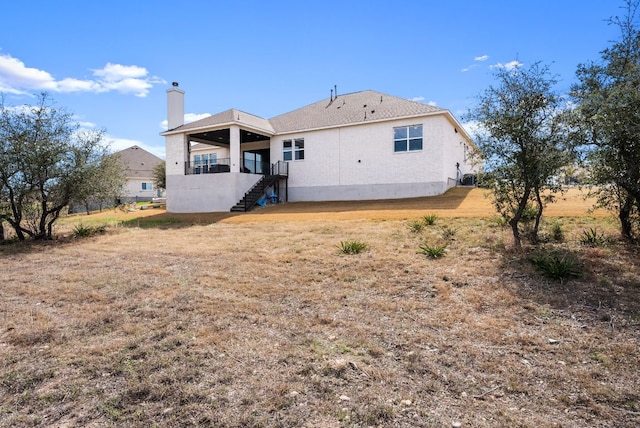 rear view of property with stairs and a chimney