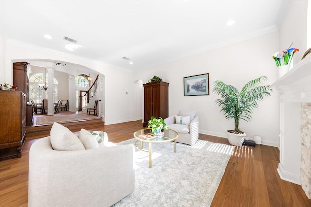10005 Cormorant Cv, Austin, TX 78730 - living room featuring ornate columns, arched walkways, stairway, light wood-type flooring, and ornamental molding