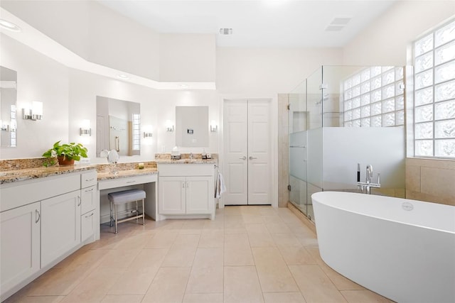 10005 Cormorant Cv, Austin, TX 78730 - full bath with plenty of natural light, a stall shower, a soaking tub, vanity, and a towering ceiling