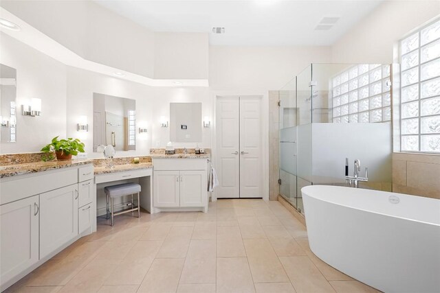 10005 Cormorant Cv, Austin, TX 78730 - bathroom featuring a stall shower, a freestanding tub, vanity, tile patterned floors, and a towering ceiling