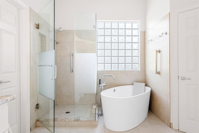 10005 Cormorant Cv, Austin, TX 78730 - full bath featuring tile walls, a shower stall, a freestanding tub, and tile patterned floors