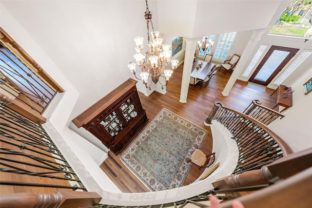 10005 Cormorant Cv, Austin, TX 78730 - living area featuring a chandelier, a high ceiling, decorative columns, and wood finished floors