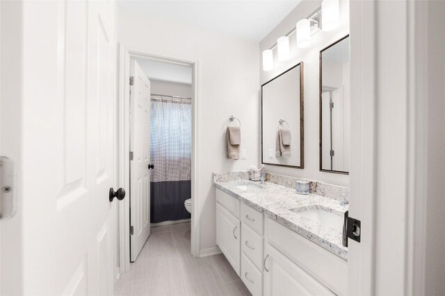 10005 Cormorant Cv, Austin, TX 78730 - bathroom with double vanity, toilet, baseboards, and a shower with shower curtain