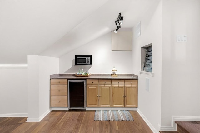 10005 Cormorant Cv, Austin, TX 78730 - indoor bar featuring wine cooler, wood finished floors, vaulted ceiling, baseboards, and stainless steel microwave