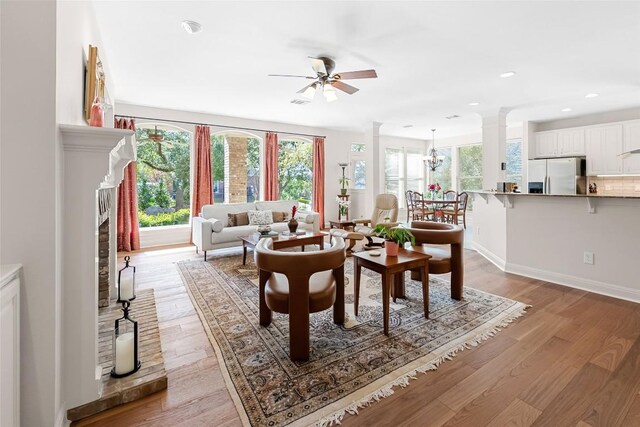 10005 Cormorant Cv, Austin, TX 78730 - living room with ornate columns, ceiling fan, light wood-style floors, a fireplace, and recessed lighting