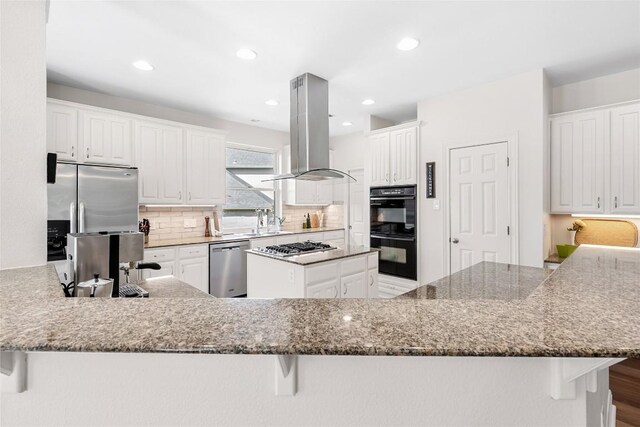 10005 Cormorant Cv, Austin, TX 78730 - kitchen featuring stainless steel appliances, island exhaust hood, white cabinets, and recessed lighting