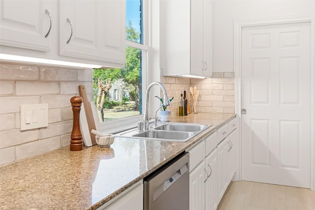 10005 Cormorant Cv, Austin, TX 78730 - kitchen featuring stainless steel dishwasher, white cabinets, a sink, and backsplash