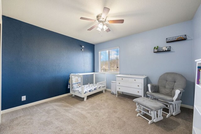 2125 Conner Dr, New Braunfels, TX 78130 - bedroom featuring carpet floors, a crib, a ceiling fan, and baseboards