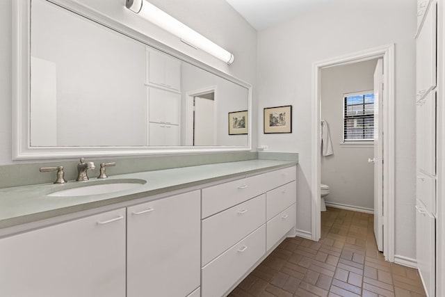 3806 Eagle Way, Round Rock, TX 78681 - bathroom featuring toilet, vanity, brick patterned floors, and baseboards