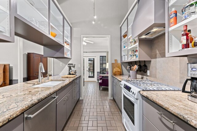 3806 Eagle Way, Round Rock, TX 78681 - kitchen with open shelves, white range with gas stovetop, gray cabinetry, a sink, and wall chimney exhaust hood